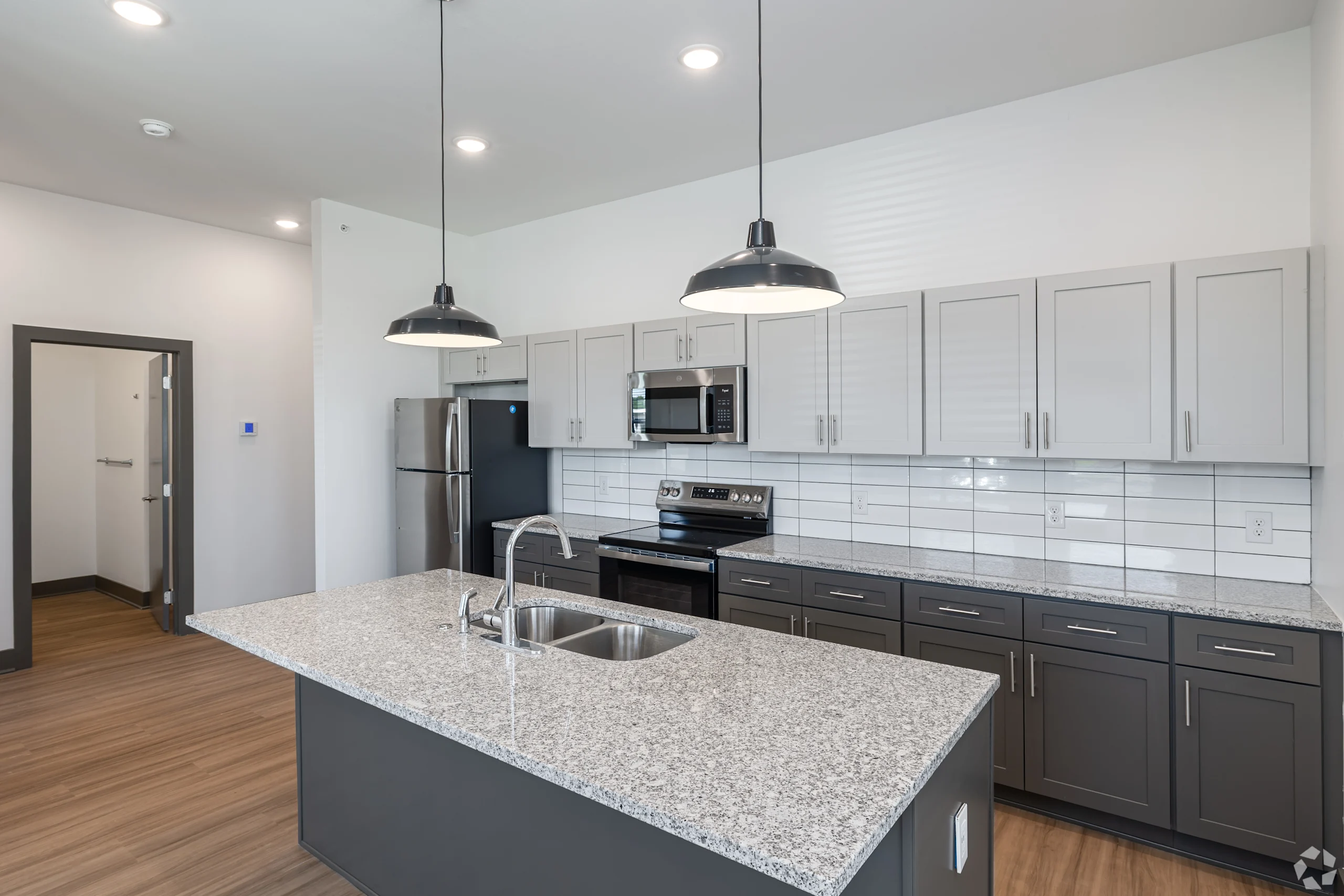 Gourmet kitchen with stainless appliances, granite island, and industrial pendant lighting